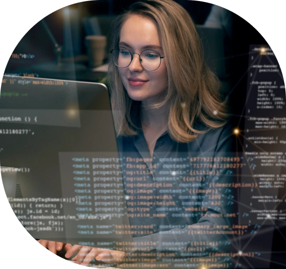 Woman in glasses coding on a computer with visible HTML meta tags and SEO optimization code, working in a tech-savvy environment.
