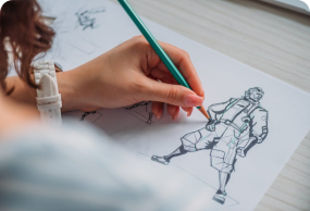 Close-up of artist sketching a cartoon character with pencil on paper, focusing on creative design and concept art.