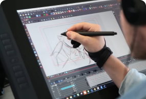 Digital artist using a pen display tablet to create character animation in graphic design software.